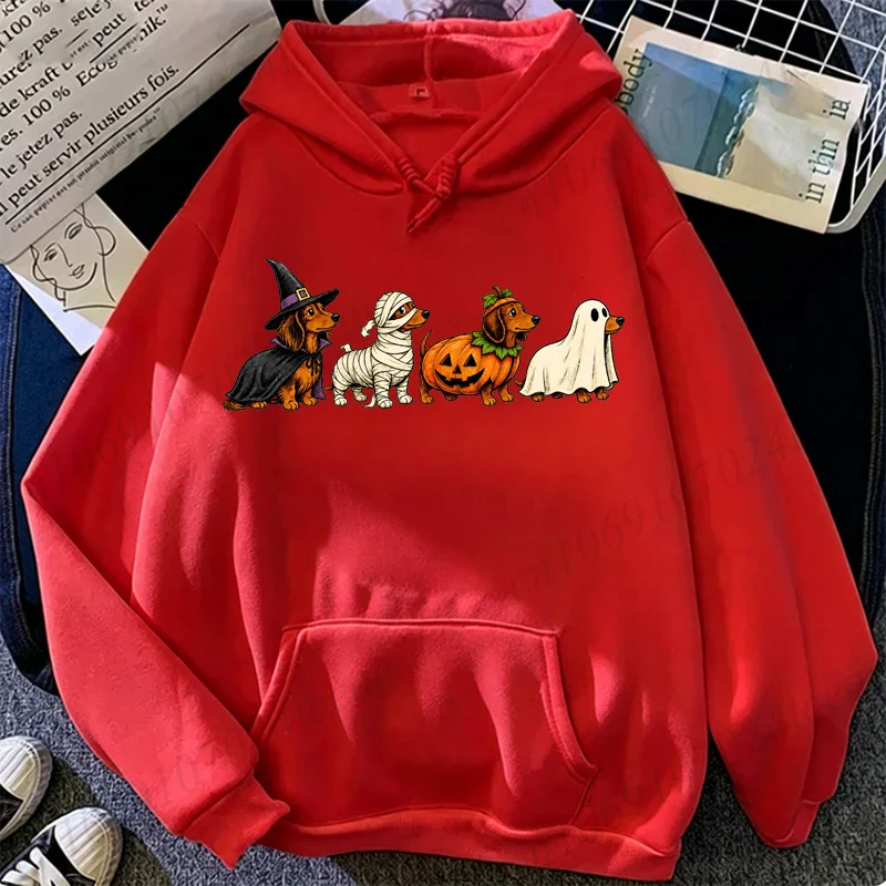 Casual women's pink pullover hoodie featuring a graphic print of four cute Dachshund dogs in Halloween costumes including a witch hat, mummy wraps, pumpkin, and ghost sheet