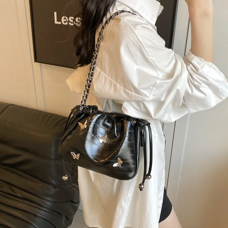 Minimalist Silver Drawstring Crossbody Bag Glossy Leather Bucket with Butterfly Charm, Perfect for Daily Commute and Casual Wear