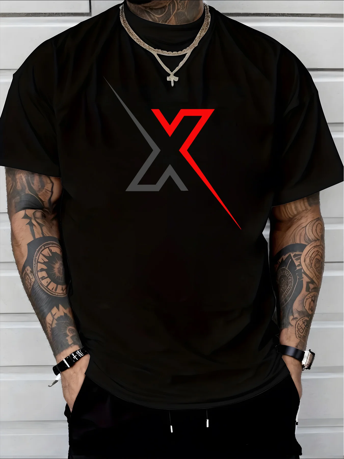 A Black T-Shirt Featuring A Bold X Logo, Adorned with A Gray Design and Red Diagonal Accents, Perfect for Those Who Appreciate Urban Fashion and Tattoos, Complemented By A Golden Necklace for A Laid-Back Look