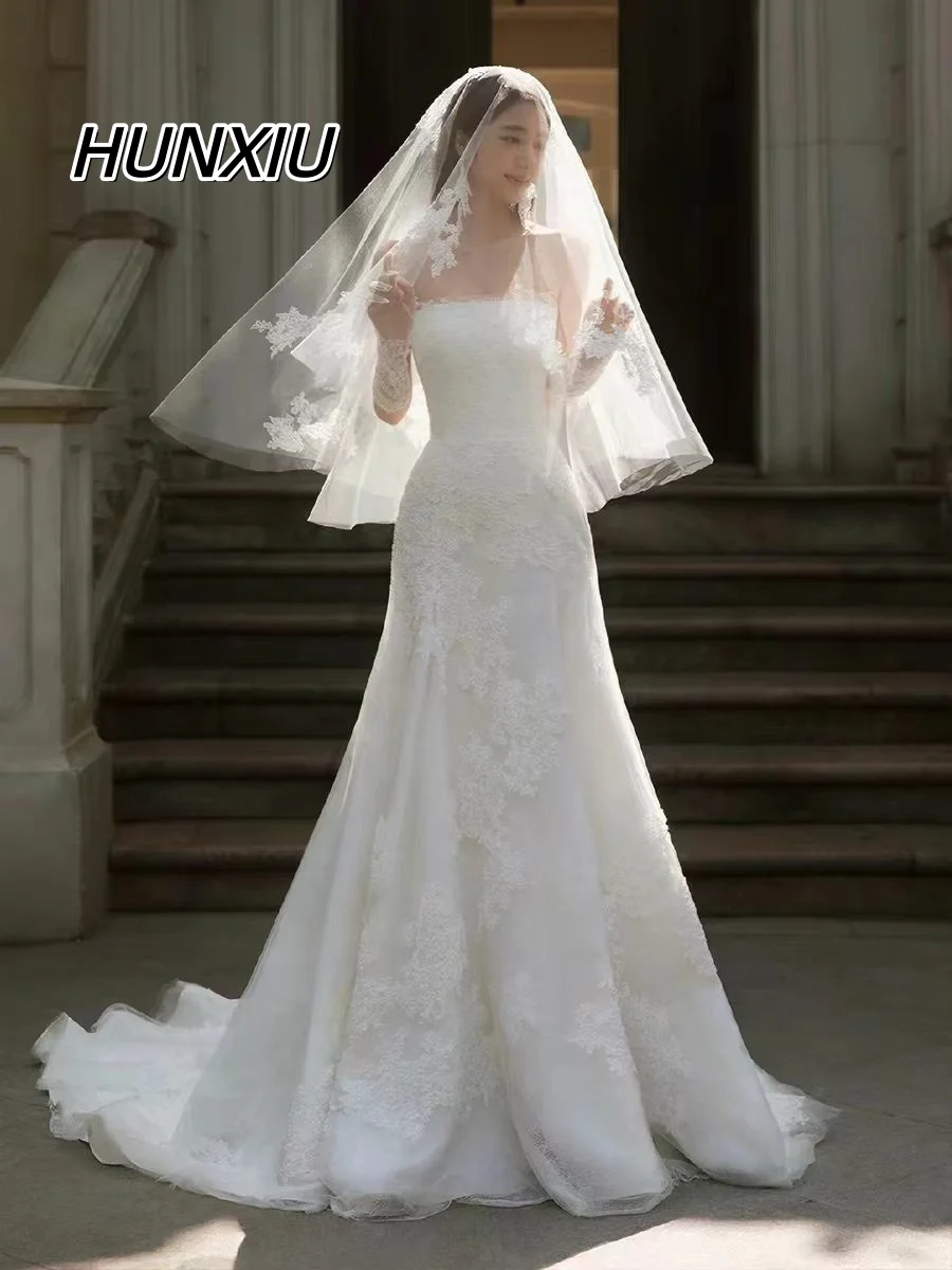 

Свадебное платье без бретелек с молнией на спине, шлейфом и кружевными аппликациями, фасон футляр. Возможность индивидуального пошива.