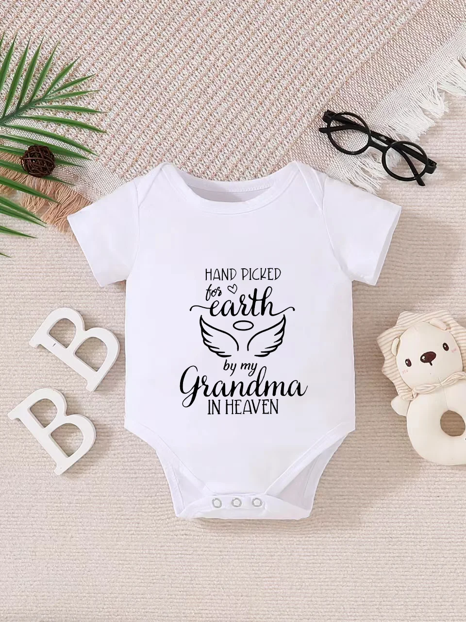 Playful letter-printed baby short-sleeve triangle bodysuit. Button closure for easy dressing, machine washable