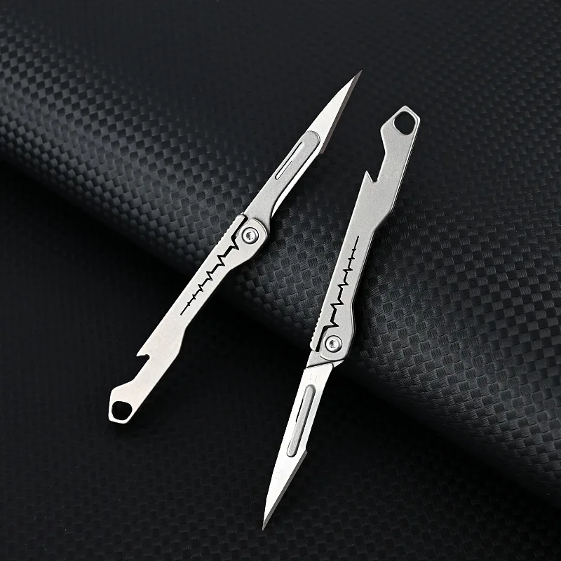 ใหม่ Mini Titanium Alloy มีดพับกลางแจ้ง Camping แบบพกพา EDC มีดมาพร้อมกับใบมีดฟรี 10 ชิ้น