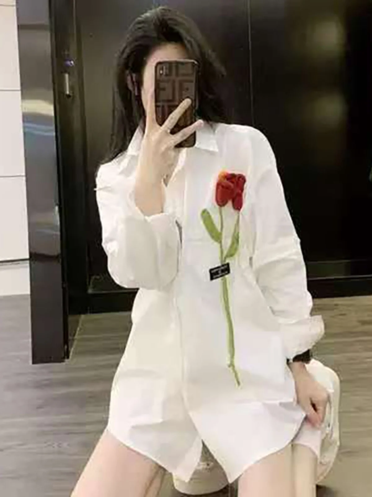 Elegancka koreańska długa biała bluzka damska z haftem róż, luźny krój, wiosenno-jesienna, modny design, casualowa, do pracy.