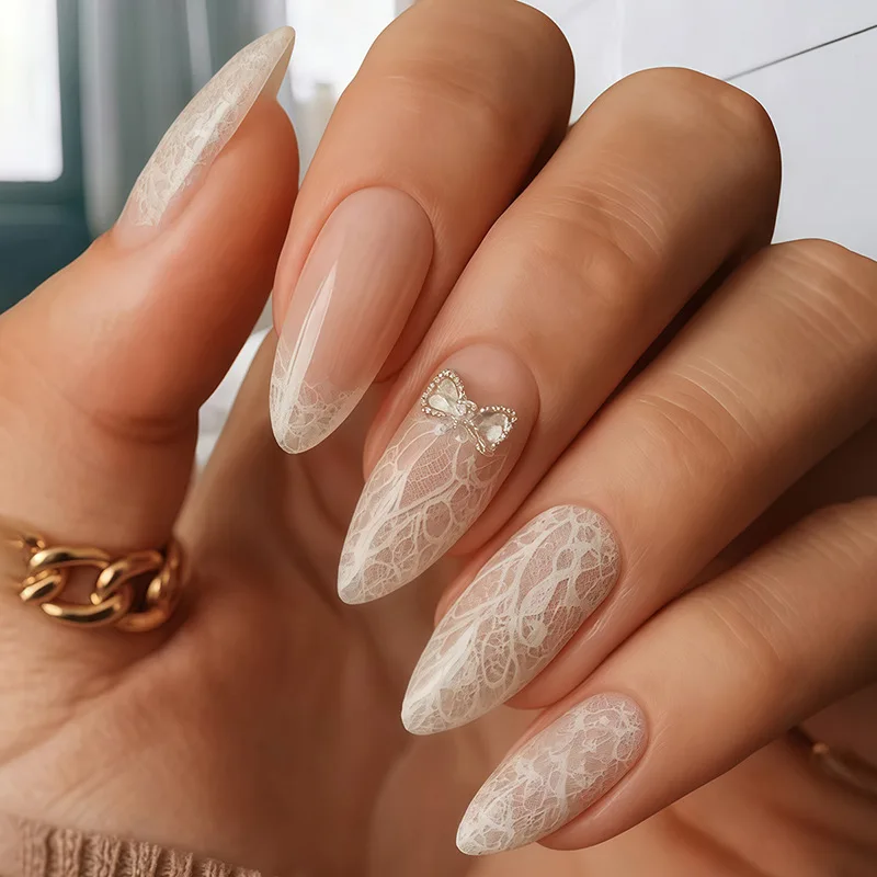 เล็บปลอมแบบกดติด 24 ชิ้น ทรงอัลมอนด์ ความยาวปานกลาง ลายลูกไม้ ประดับผงวิ้ง ดีไซน์เต็มเล็บ พร้อมโบว์ 3 มิติ และเพชร ใช้ซ้ำได้