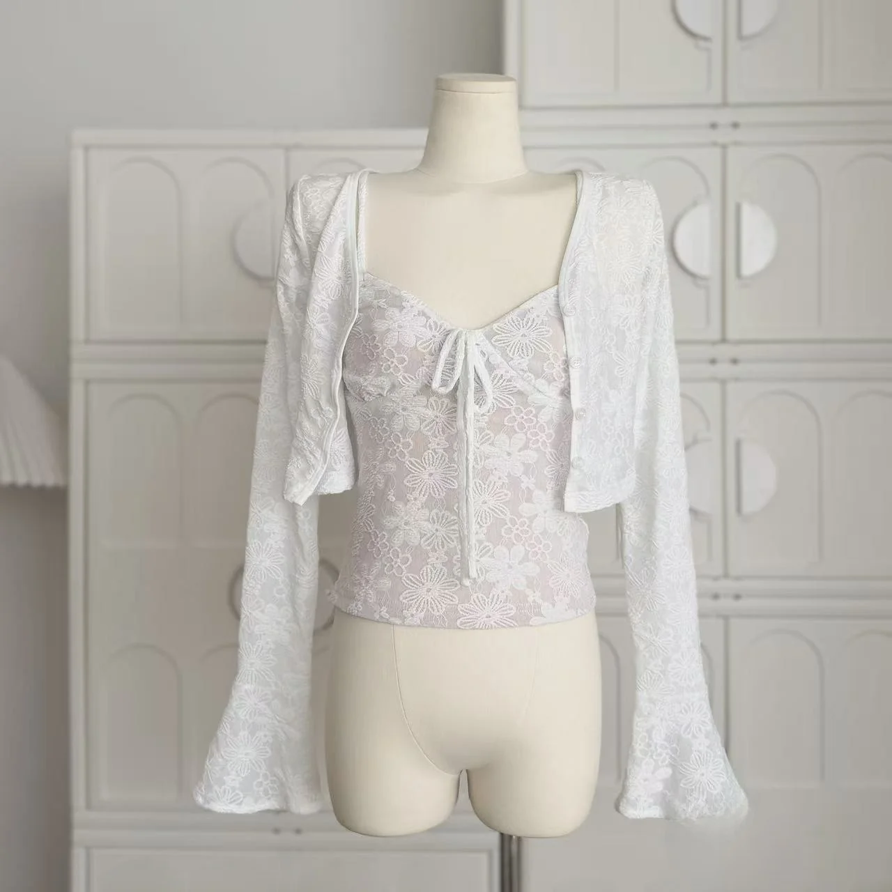 

Эластичный кружевной комплект из двух предметов: кардиган с цветочной вышивкой и рукавами-колокол, топ на бретельках. Женская модная коллекция Весна.