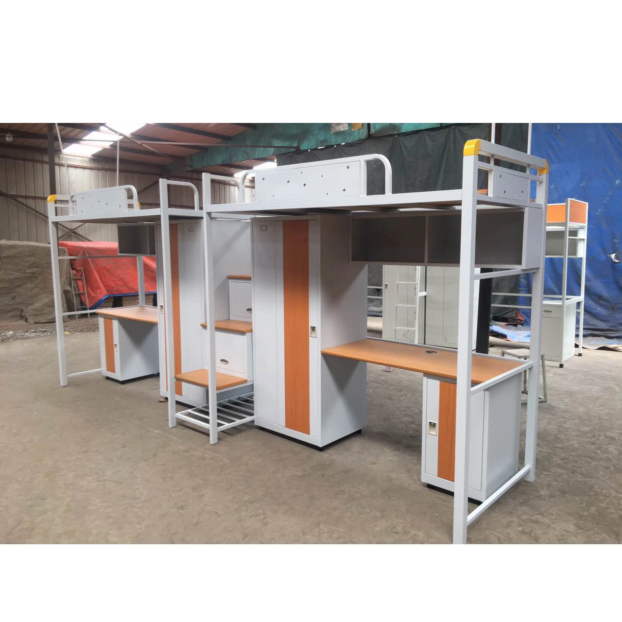 เตียงสองชั้นเหล็กสำหรับนักเรียนในหอพักพร้อมโต๊ะเขียนหนังสือและโต๊ะทำงานสำหรับผู้ใหญ่