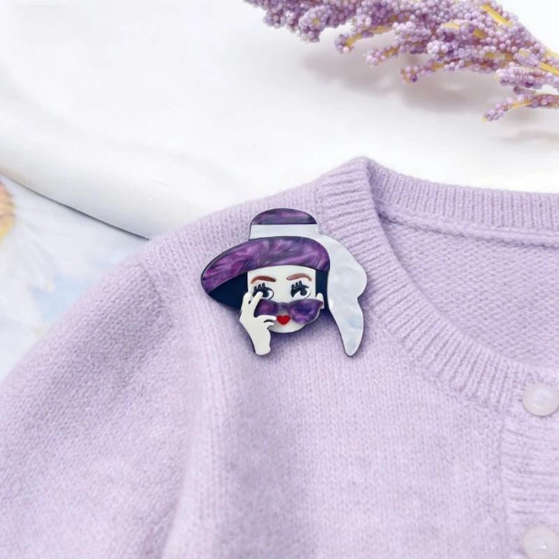 

Девушка в шляпе носит модную и креативную акриловую брошь в качестве декоративного аксессуара.