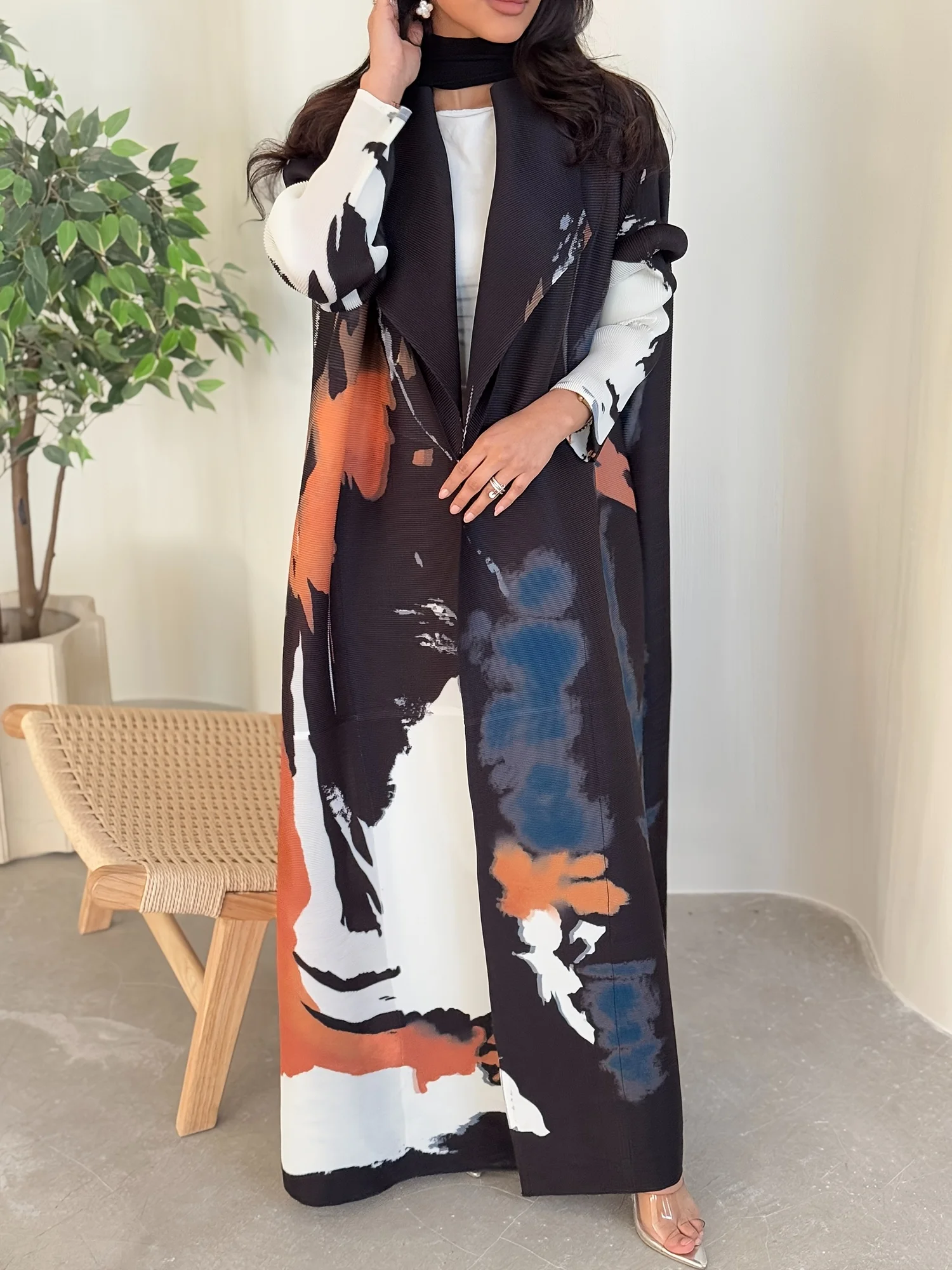 An A-line women's abaya robe made of pleated printed fabric. It comes with a belt to cinch the waist. Suitable for Ramadan.