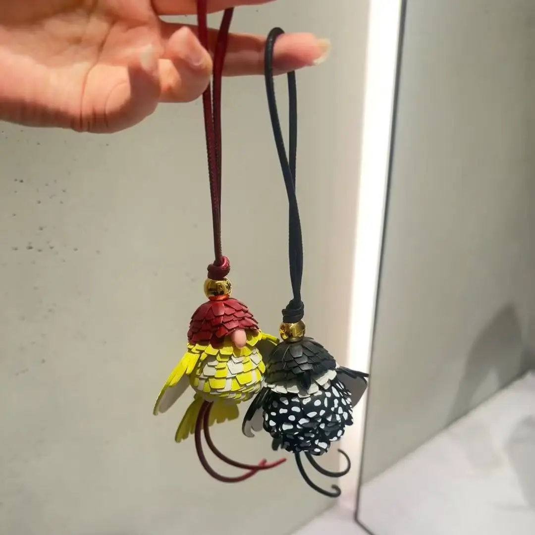 breloque-de-sac-artisanale-en-cuir-veritable-motif-perroquet-jaune-et-noir-avec-sangle-tressee-et-anneau-dore