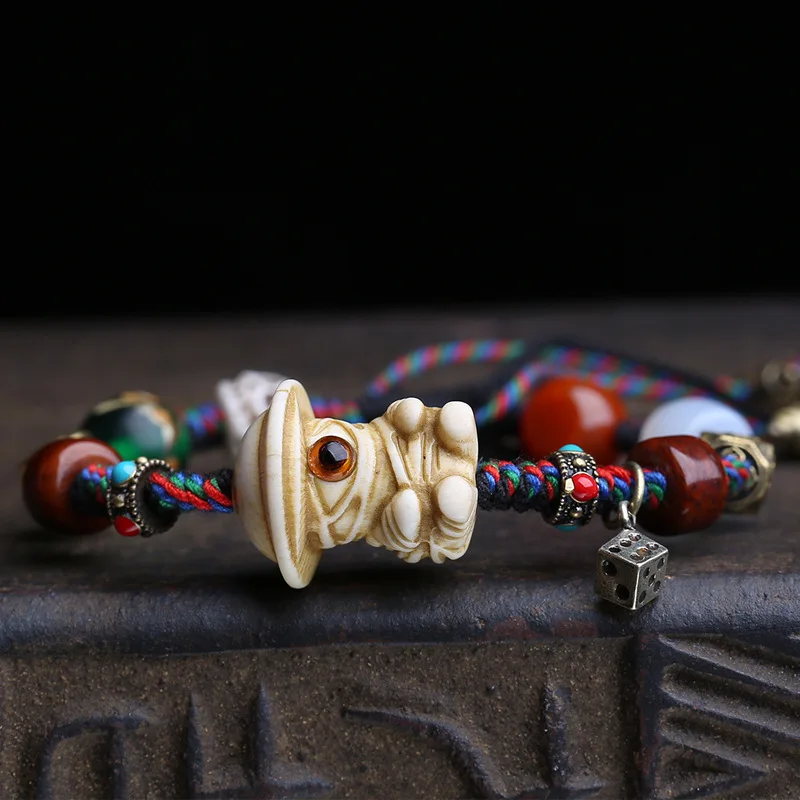 Natural antler carving one-eyed monster motif, handmade woven rope bracelet with agate, glass, bone, and copper accessories
