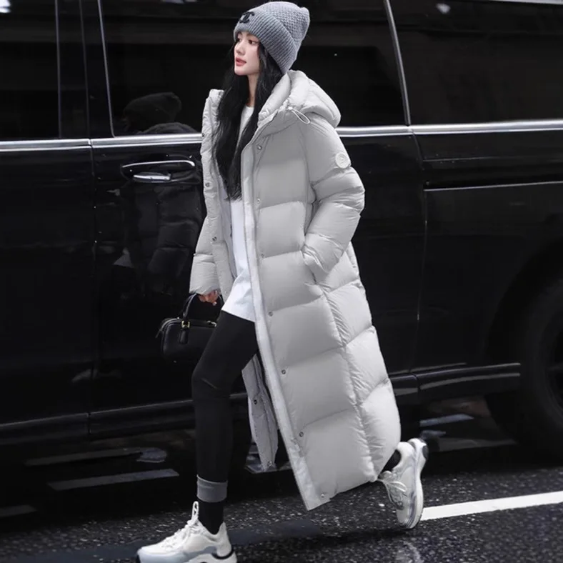 سترة بغطاء للرأس طويلة وقصيرة مقاومة للبرودة للنساء في شتاء 2025، طراز جديد عصري مع حزام ذراع سميك وأبيض