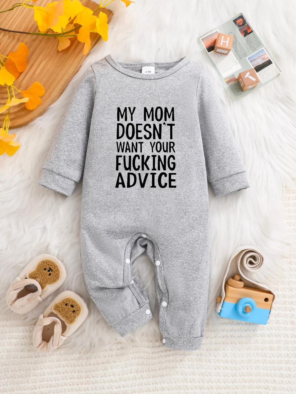 A baby long-sleeved onesie with interesting letter prints. It features a buttoned design for easy putting on and taking off