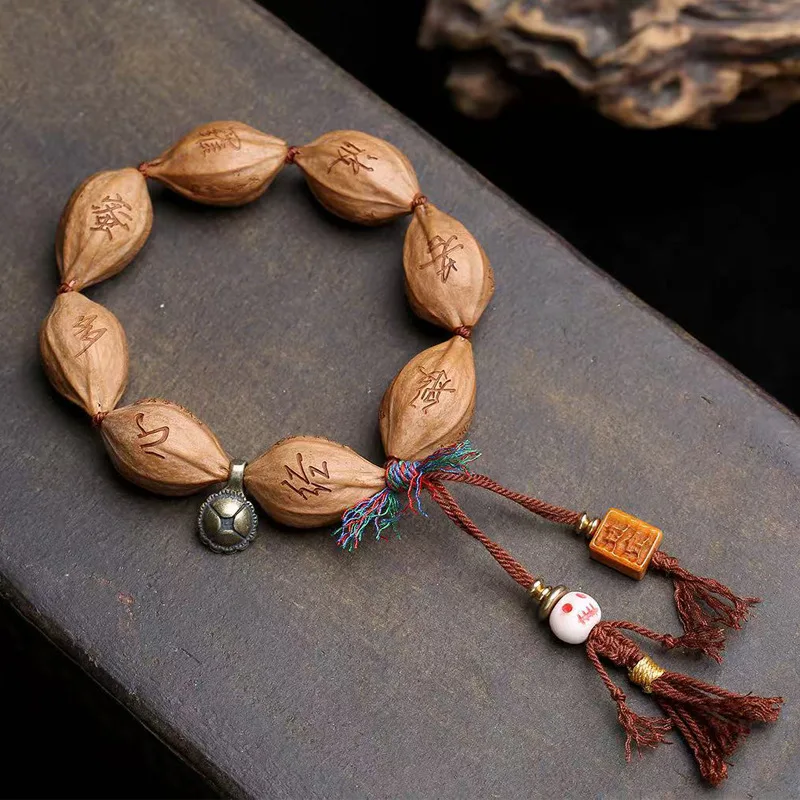 Hand-woven bracelet featuring natural olive pits engraved with the Heart Sutra, with copper clasps and recycled bone accents