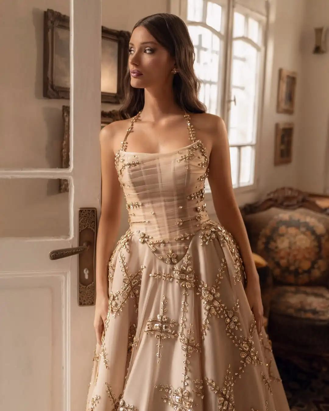 L'une robe de mariée personnalisée FATAPAESE comprend une jupe volumineuse en tombe de champagne décennement ornée de cristaux dispersés étincelles