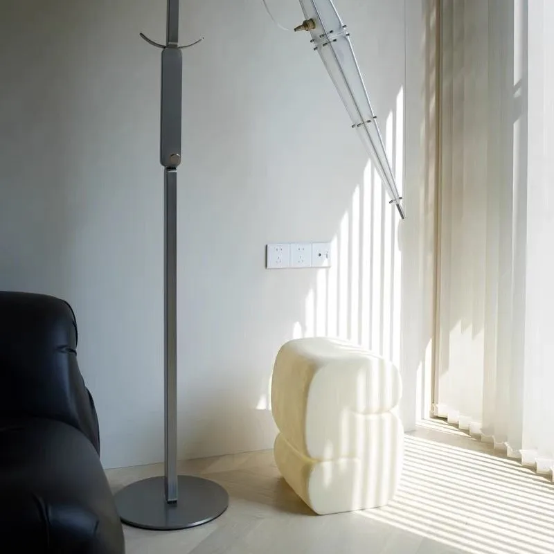 The floor-to-ceiling coat rack is a stainless steel simple modern sculpture-like household hanger.