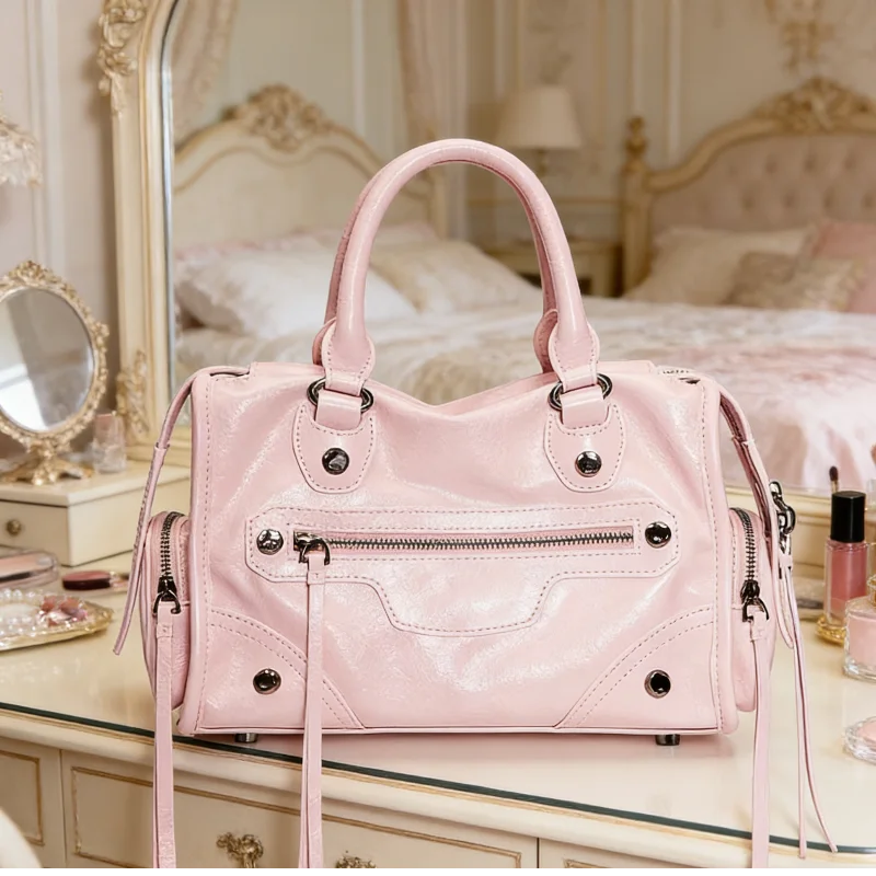 

Стильная розовая сумка-кроссбоди в байкерском стиле, вдохновленная винтажным дизайном, с застежкой-молнией, декорированная цепочками и заклепками, с множеством карманов и элементами в виде кисточек.