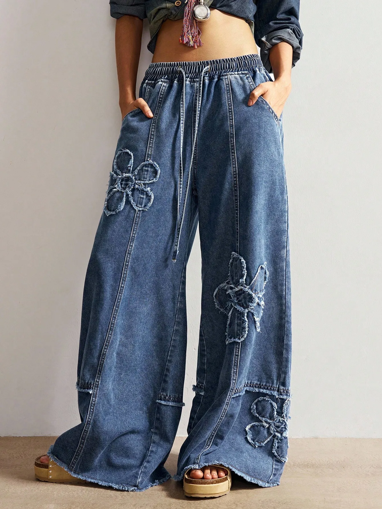 

Женские широкие джинсы с цветочным аппликацией и завязками на талии