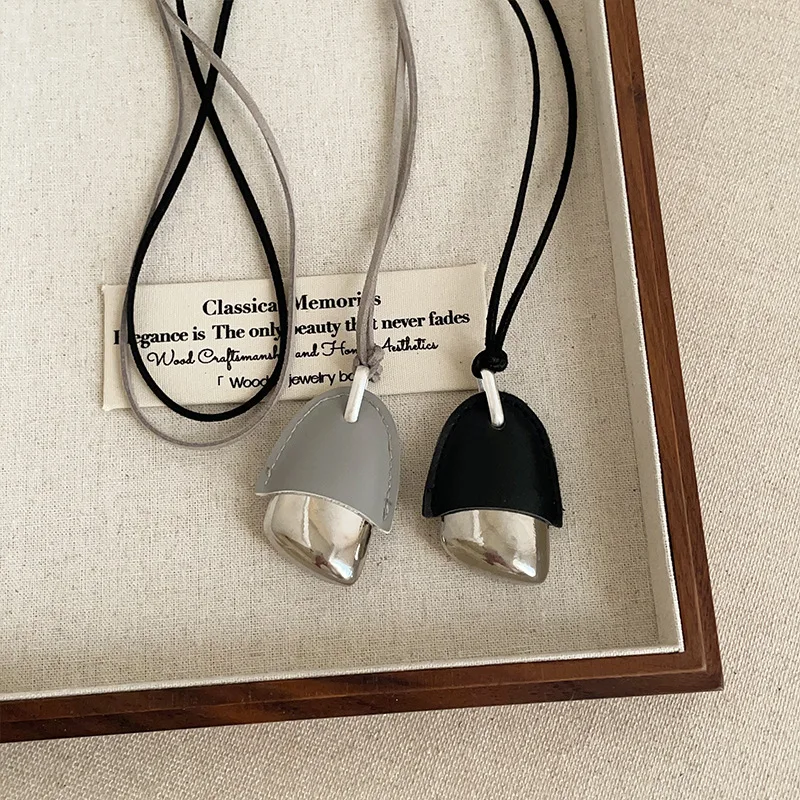 

2025The new Black Light Blue PU Leather Metallic Pinecone Pendant Necklace for Women Long Adjustable Rope Chain Chokers