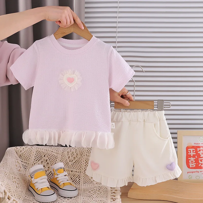 

Новый летний комплект одежды для девочек 2026 года: футболка с текстурным тюлем и оборками в форме сердца и шорты с оборками. Милый наряд для малышей 0-5 лет.