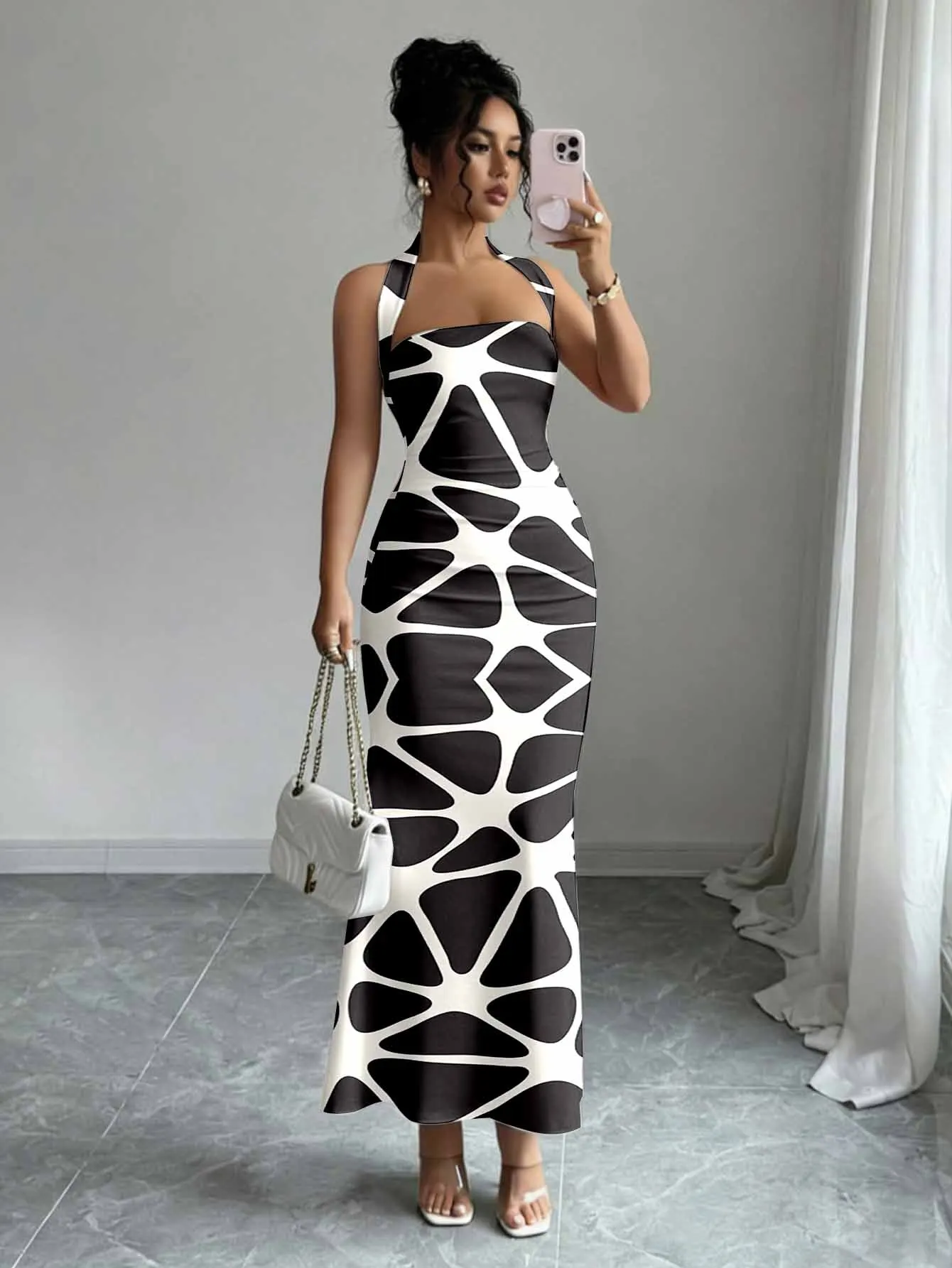 Tailored hip hugging fishtail dress with a hanging neck and sleeveless design that highlights feminine lines
