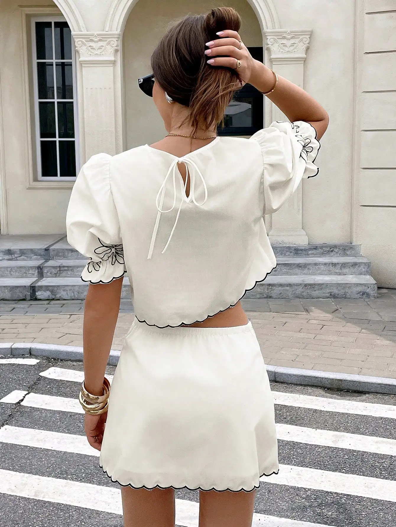 Completo due pezzi da donna bianco con ricamo a margherite, maniche a sbuffo e orlo smerlato, outfit casual estivo