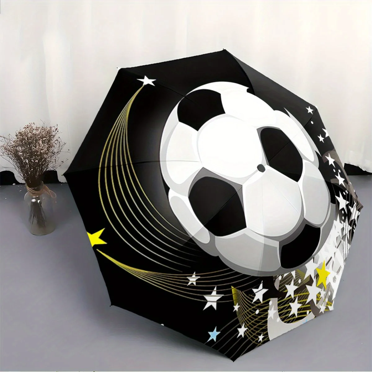 

Folding Umbrella The umbrella features a soccer ball as the main design, with star patterns and curved yellow streaks. Fits Tr