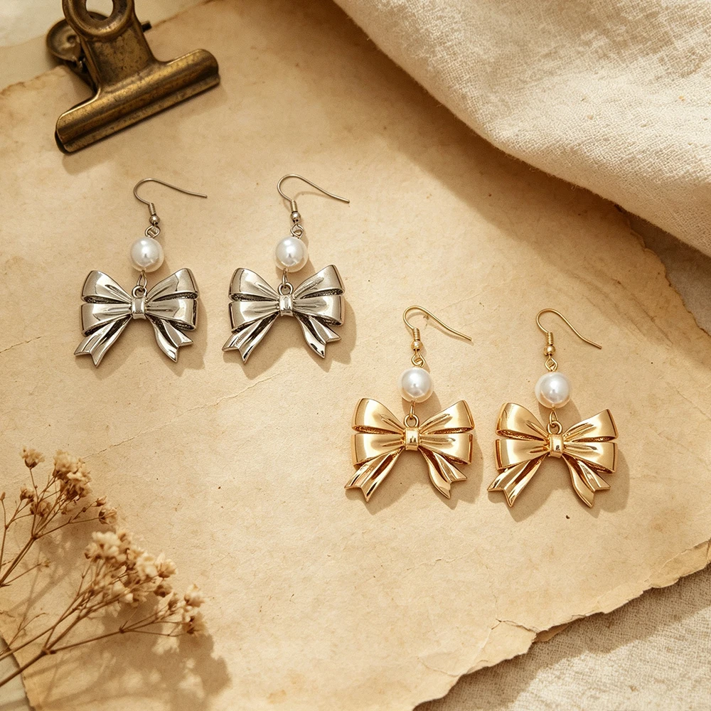 Three-dimensional metal bow paired with round faux pearls, in gold and silver tones, simple and vintage, with a graceful dangle, suitable for both work and dates.