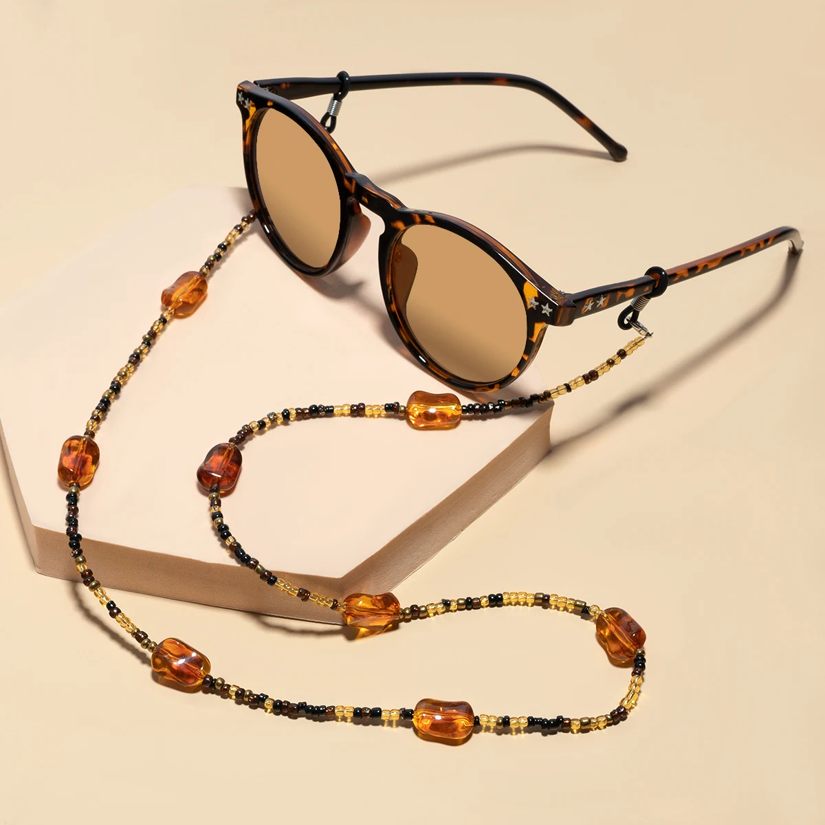 Die Retro-Brillenkette in Bernsteinfarbe ist ein modisches Accessoire für Damen und Herren. Es verfügt über eine Anti-Rutsch-Funktion und eine Gesichtsschutzfunktion. – Detail 1