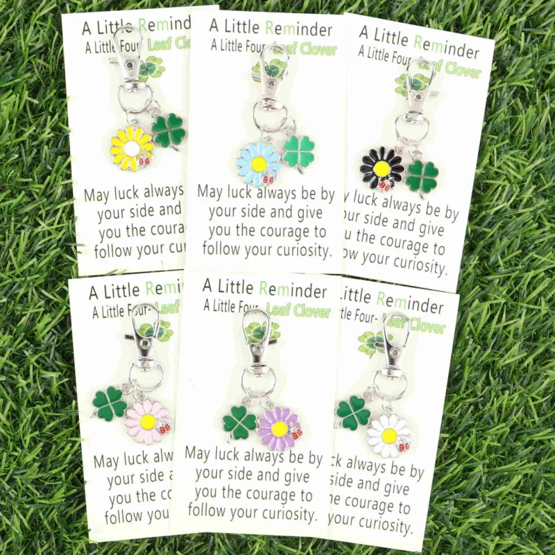 Juego de 6 llaveros interesantes con diseño de margarita y trébol de cuatro hojas, con una pequeña tarjeta de trébol de cuatro hojas, se pueden usar para decorar ropa y bolsos.