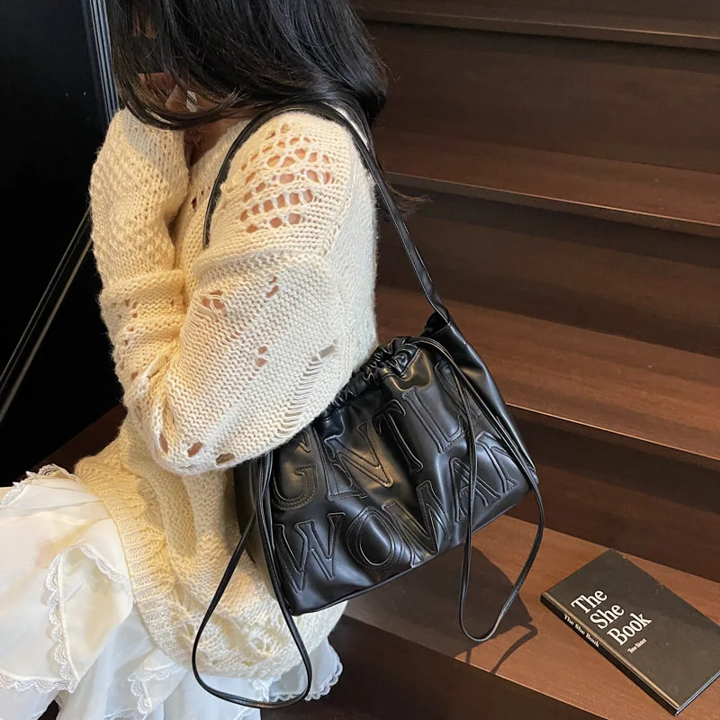 

Новая текстурированная сумка-пельмень 2026 года: сумка-тоут на плечо с завязками и надписью — где мода встречается с функциональностью