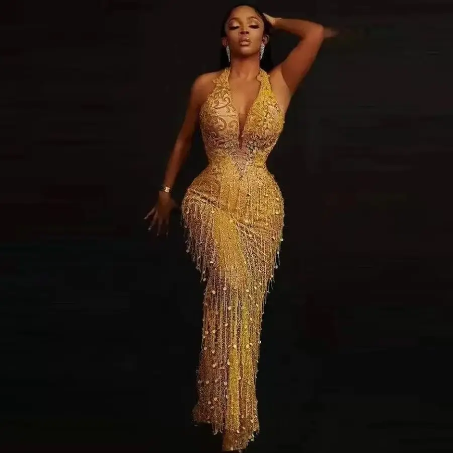 ชุดราตรีแบบไม่มีแขนประดับลูกไม้และพู่ห้อยสไตล์หรูหราสำหรับสาวผิวสี ชุดออกงานทางการสำหรับผู้หญิง ชุดราตรีทรงเมอร์เมดแบบผูกคอสีทองสำหรับงานพรอม