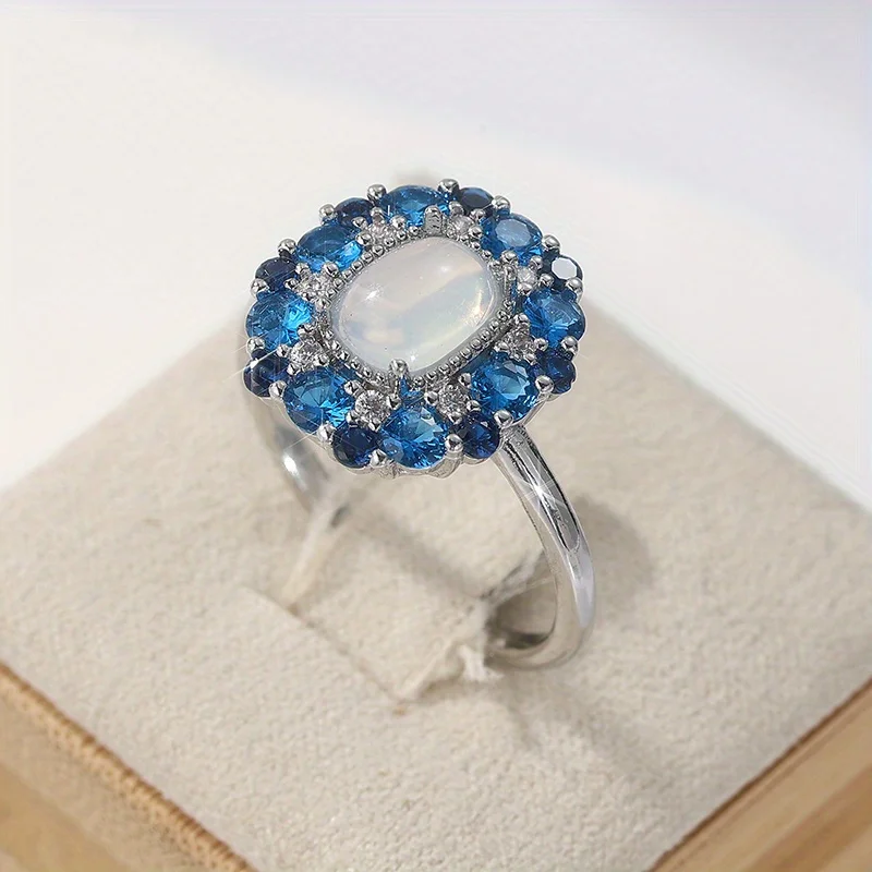 Damenmode-Ring aus Kupfermaterial mit eingelegtem blauem synthetischem Zirkon, ergänzt durch einen Mondsteinring, elegantes Schmuckzubehör.