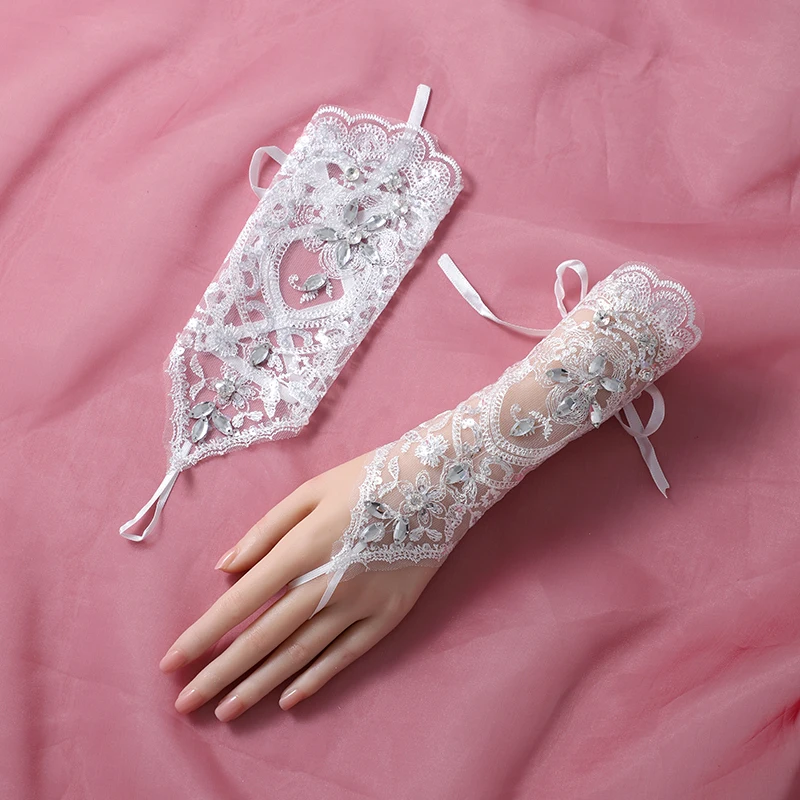 The bride's accessory is a pair of white ring style mid length gloves suitable for women's wedding parties