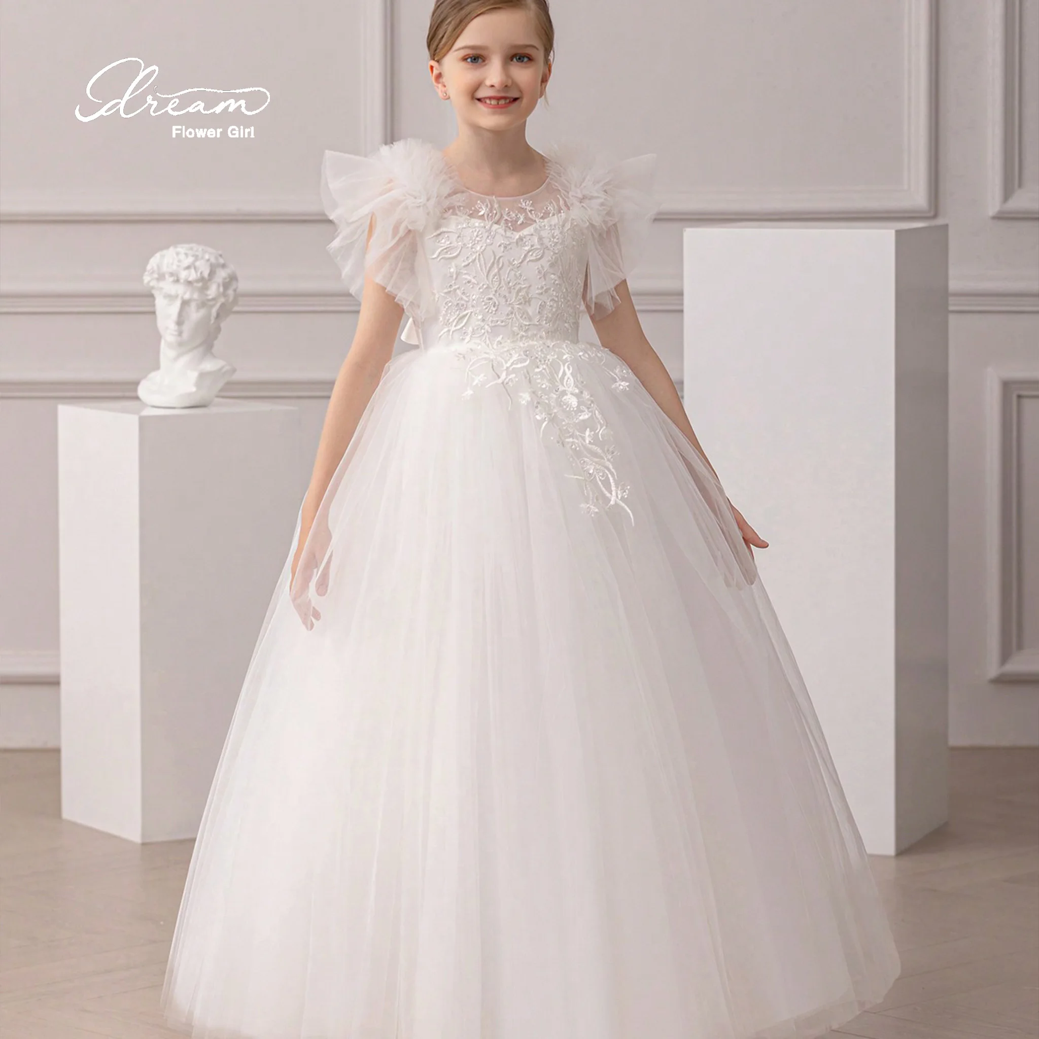 Girls' white round-neck formal party dress with a full skirt featuring tulle embroidery and a bow at the back