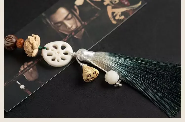 Le pendentif à pampilles en forme de fleur de bac de lotus "Chen Qing Ling" est entouré par le pendentif à pompon de flûte de Wei Wuxian