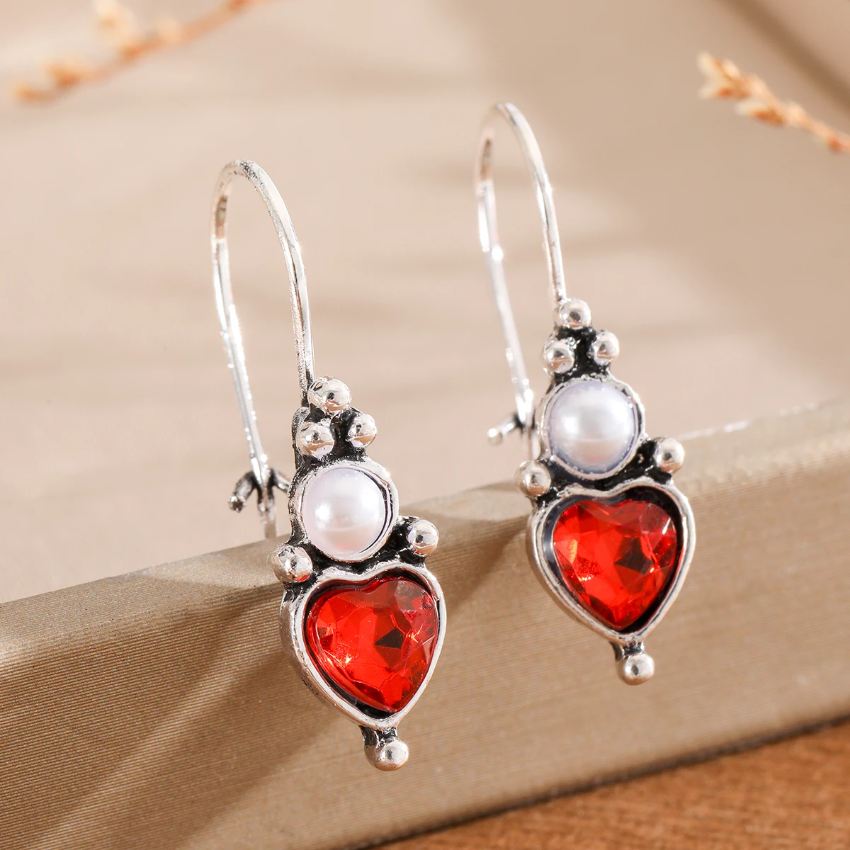 Elegant upper layer resembling pearls, lower layer with heart-shaped inlay. Women's pendant earrings for dates and parties.