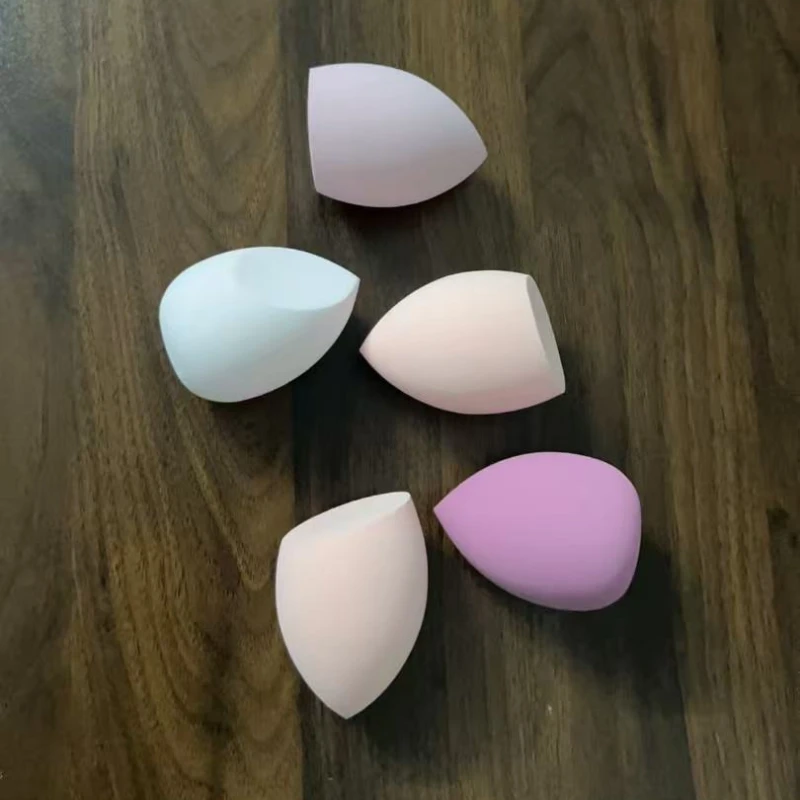 Oeuf de maquillage imbibé dans l'eau pour devenir plus grand et humide. L'éponge d'œuf de maquillage à double usage ne mange pas l'œuf de maquillage pastel