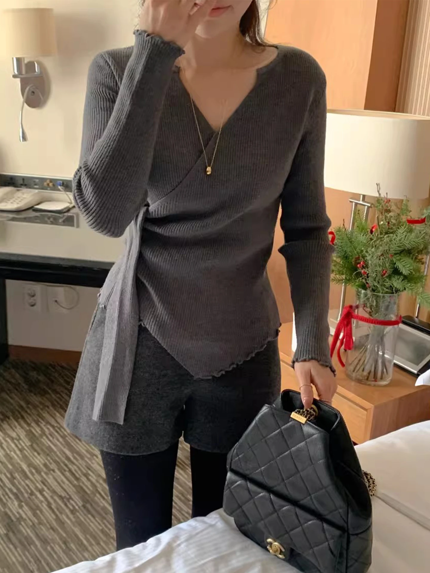 เสื้อสเวตเตอร์ถักคอวีไขว้สำหรับผู้หญิง ทรงเข้ารูป ใส่เป็นเสื้อตัวในได้ เหมาะสำหรับฤดูใบไม้ร่วงและฤดูหนาว เนื้อผ้านุ่มสบาย ดีไซน์ทันสมัย พร้อมดีเทลผูกโบว์ที่คอเสื้อ