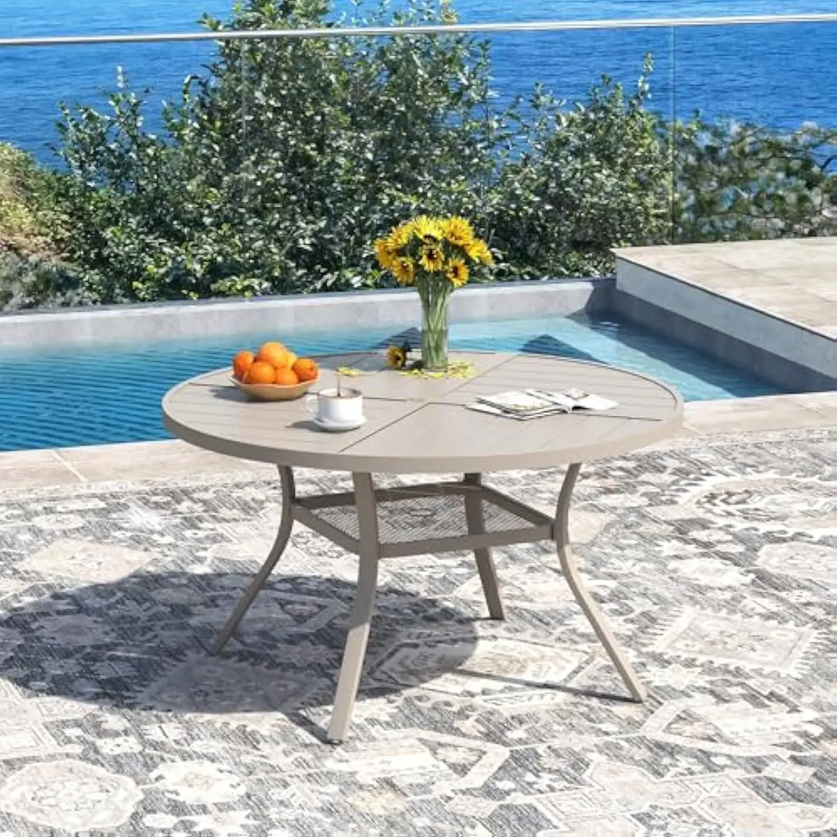 Outdoor dining ensemble for four persons featuring round metal table with integrated umbrella aperture and four ergonomic stacka