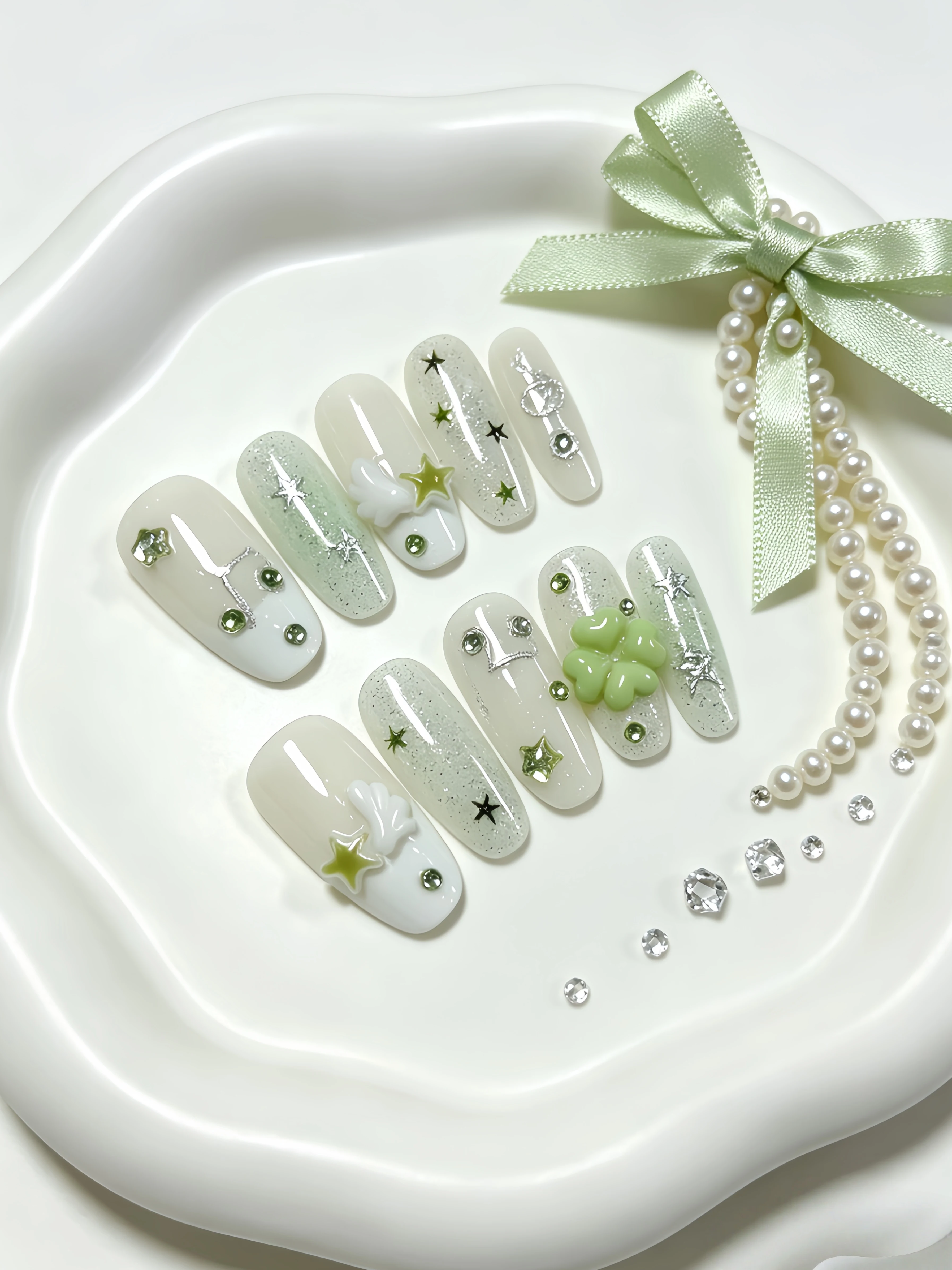 10 Pieces of Medium-Length Oval-Shaped Wearable Nails, Featuring a Fresh and Simple Design with Milk White and Light Green Gradient, Silver Glitter Stars, Rhinestones, Musical Notes, 3D Four-Leaf Clover Wings, and Five-Pointed Stars Embellishments