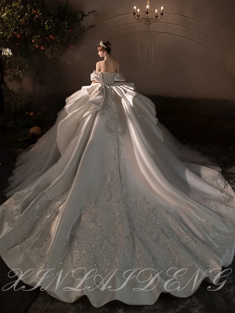 Ein neues, strapazierfähiges One-Shoulder-Kleid aus Satin mit großem Schwanz