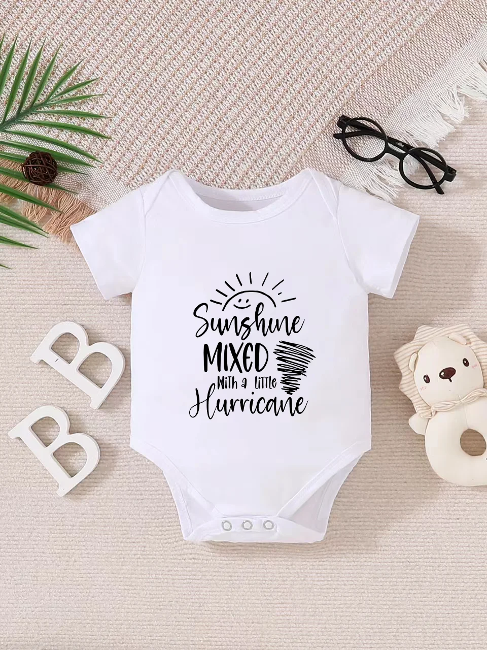 Playful letter-printed baby short-sleeve triangle bodysuit. Button closure for easy dressing