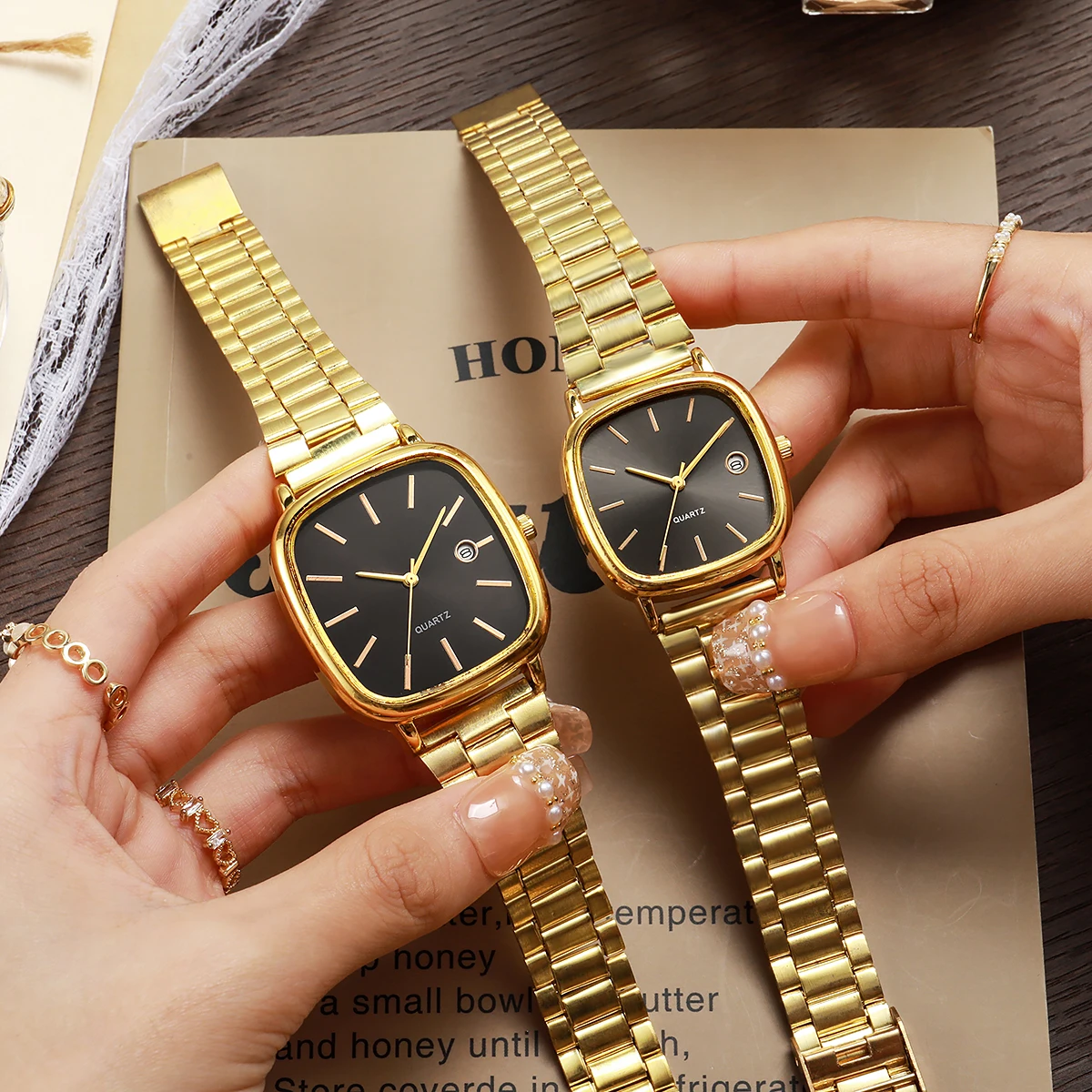 

Элегантный комплект парных часов в золотистом цвете с квадратным корпусом - мужские и женские наручные часы с черным циферблатом, окошком для даты, браслетом из нержавеющей стали, кварцевый механизм.