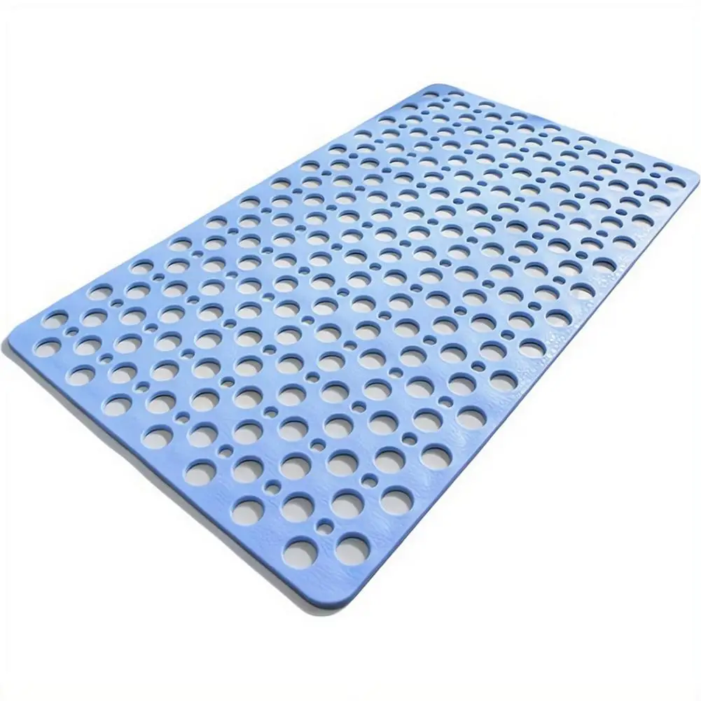 Blue shower mat with suction cups and large drainage holes on a wet bathroom floor.
