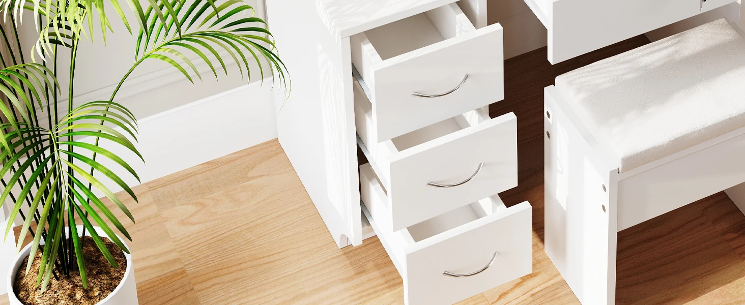 White storage unit with three pull-out drawers, placed next to a potted palm plant on a wooden floor. The unit appears to fit under a larger piece of furniture.