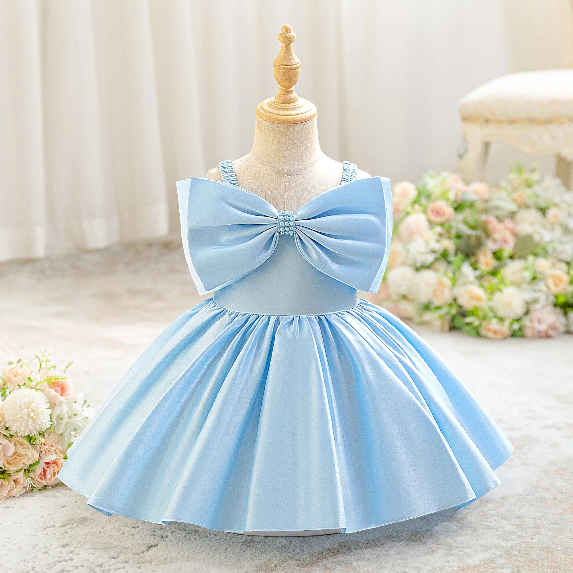 Stylish blue satin princess dress with a bow for a baby girl's first birthday