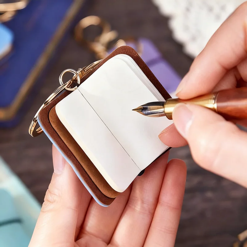 سلسلة مفاتيح Mr. Paper مكونة من قطعتين من البولي يوريثان - مذكرات صغيرة محمولة من الجلد الناعم، دفتر ملاحظات ساحر على الظهر، ملحقات تخزين على الطراز الأدبي
