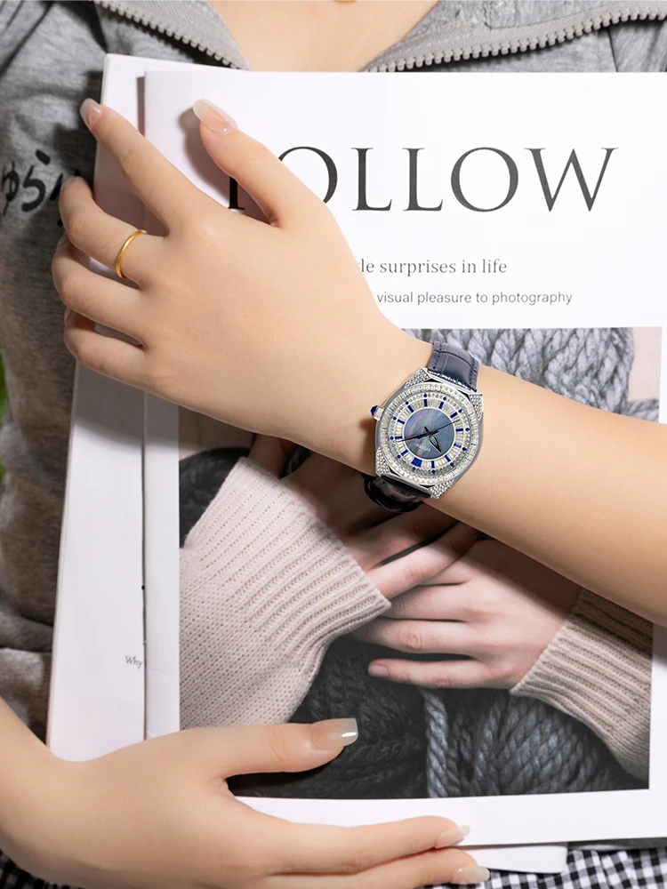 stylish and sophisticated women's watch with a unique design featuring a round mother-of-pearl dial and a black leather strap.