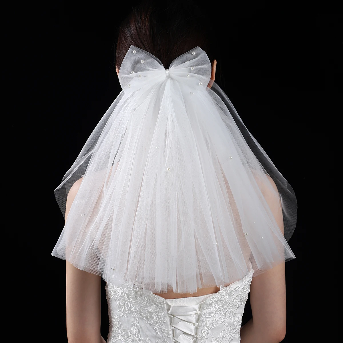 A white elegant bridal veil adorned with a simple bow, shoulder length veil suitable for women's weddings