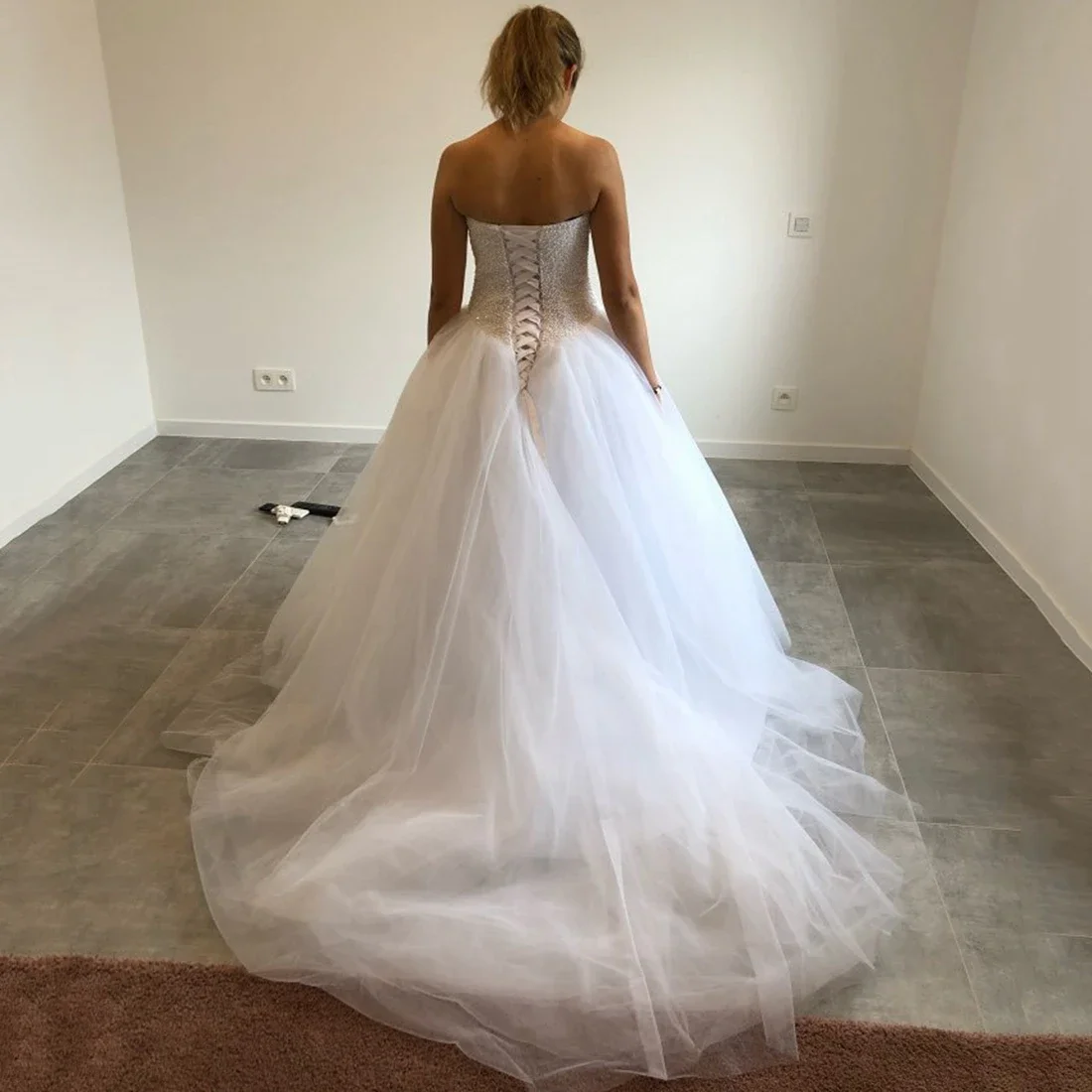 Elegante vestido de novia de tul con destino estilo bosque y cola de corte con cuentas hecha a mano